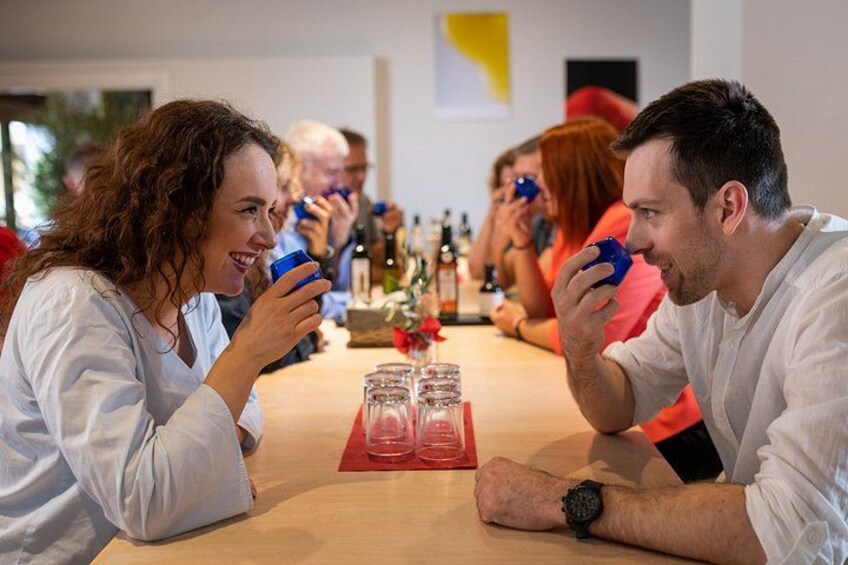 People sitting at a table with drinks and glasses. 1