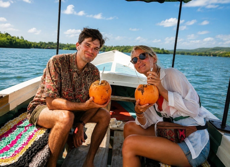 Two people on a boat holding coconuts. 2