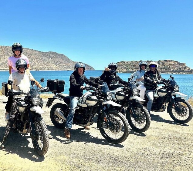 A group of people on motorcycles by a coastal road with a clear sky. 2