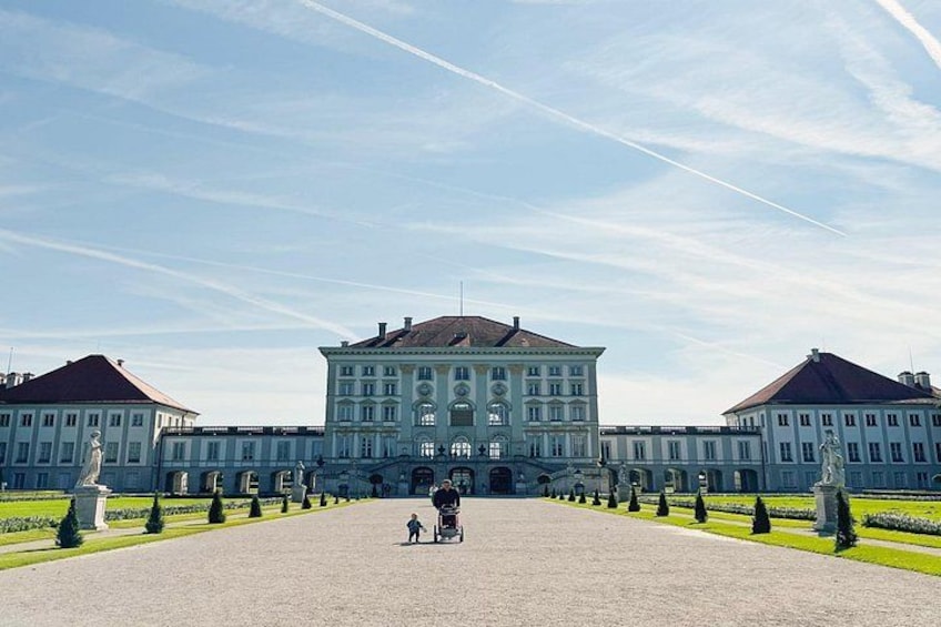 A grand building with symmetrical architecture, a wide paved area, and a statue in the foreground. 5