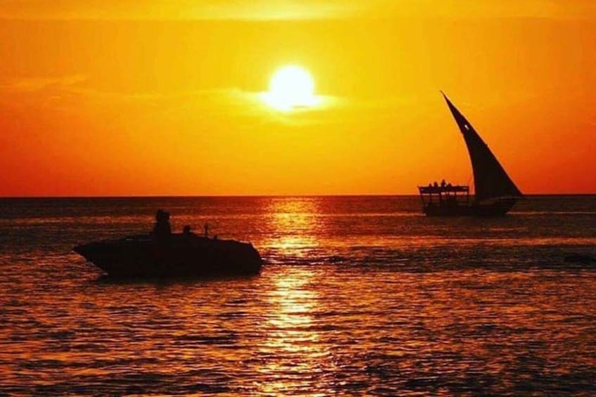A sunset over the ocean with a boat and a sailboat. 1