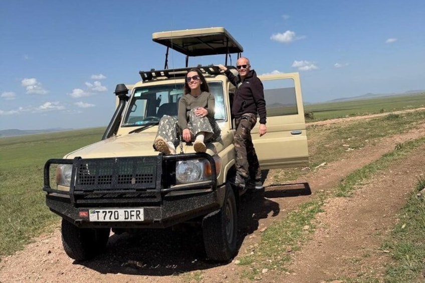 A beige off-road vehicle with a license plate 'T770 DFR' parked on a dirt path in a grassy field. 1