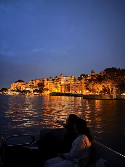A river with a historic building on the opposite bank, illuminated at dusk. 3