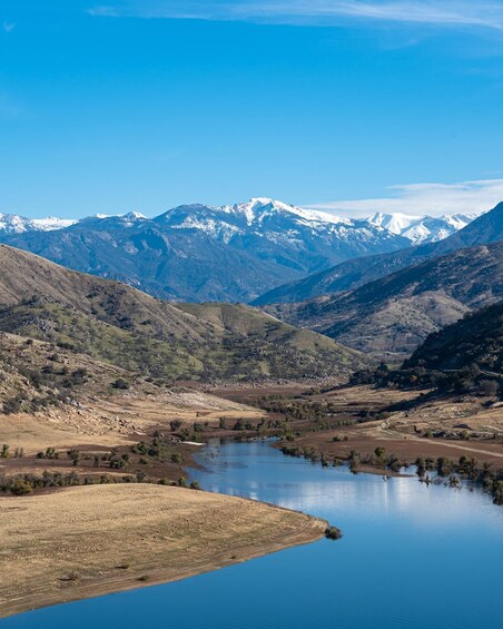 A mountainous landscape with a lake and snow-capped peaks in the distance. 2