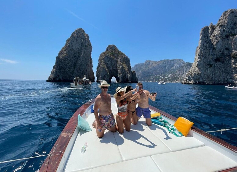 A boat with people on a clear day, rocky cliffs in the background. 3