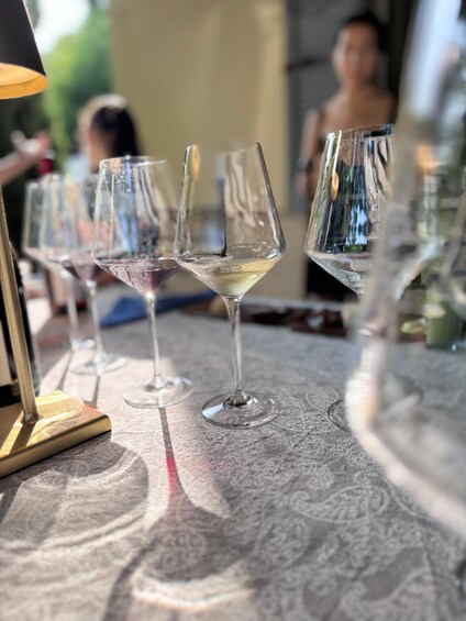 A row of empty wine glasses on a patterned tablecloth. 5