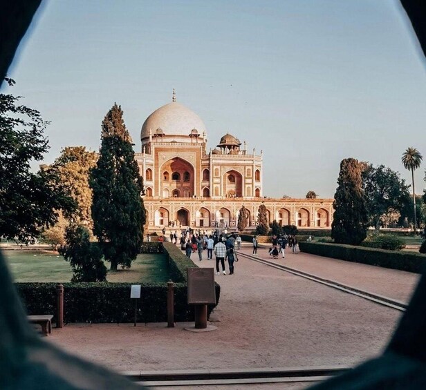 A large, historic building with a dome and arched windows, surrounded by a well-maintained garden and pathways. 4