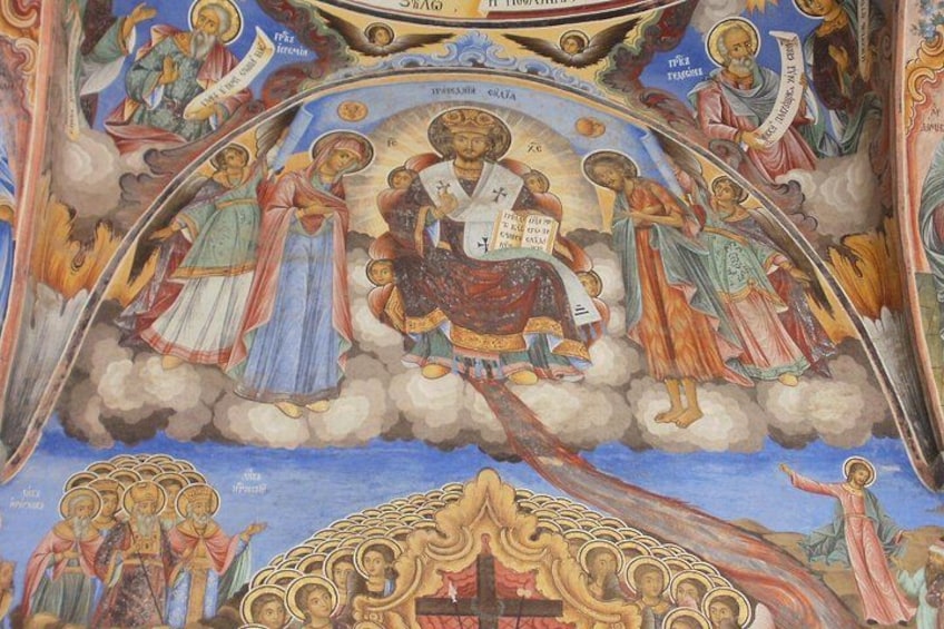 Un affresco religioso raffigura figure in abiti talari, una figura centrale seduta su un trono, e un gruppo di angeli. 5