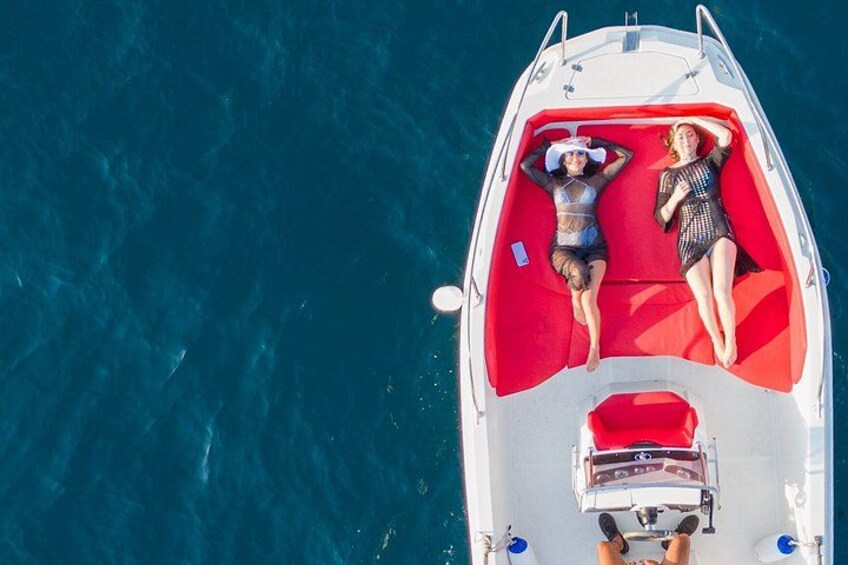 A boat with two people lying on a red deck. 2