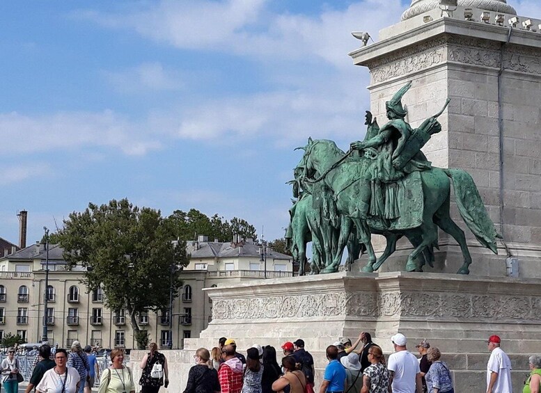 A bronze equestrian statue with a crowd of people in the foreground. 3
