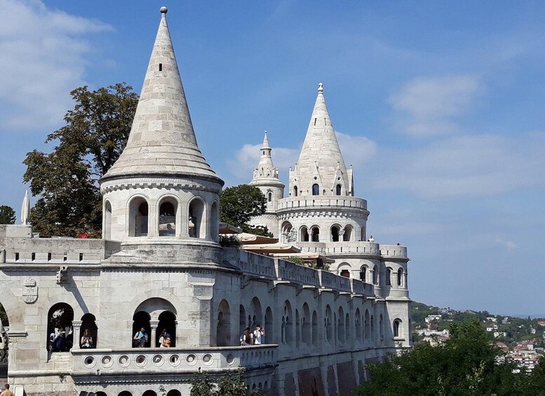 A historic building with multiple conical towers and arched windows. 1
