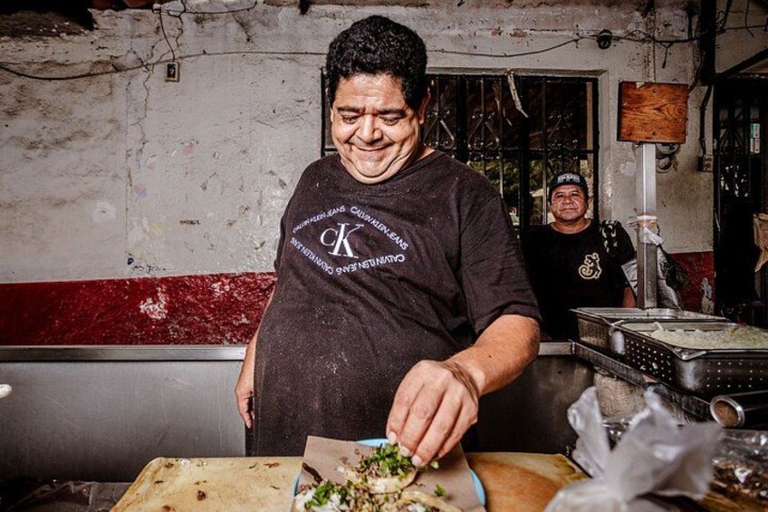 Una persona preparando comida en una cocina, con una tabla de cortar, un cuchillo y varios utensilios de cocina. 5