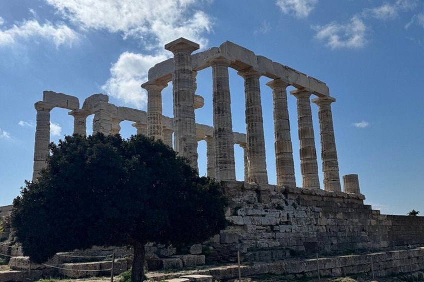 Ancient Greek ruins with columns and a tree in the foreground. 5