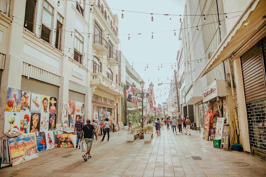 A pedestrian street lined with art displays and closed shops. 4