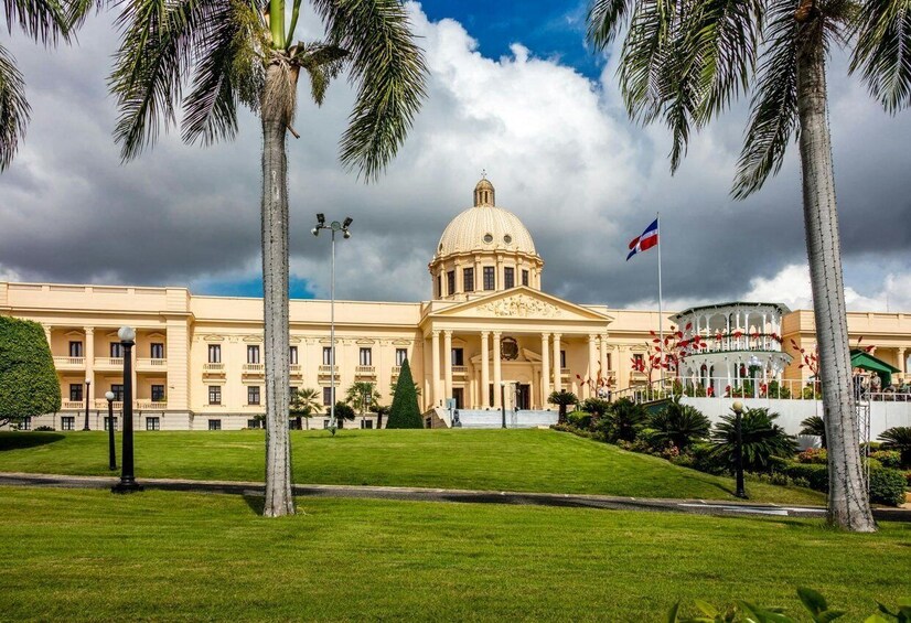 A neoclassical building with a dome, palm trees, and a flag. 1