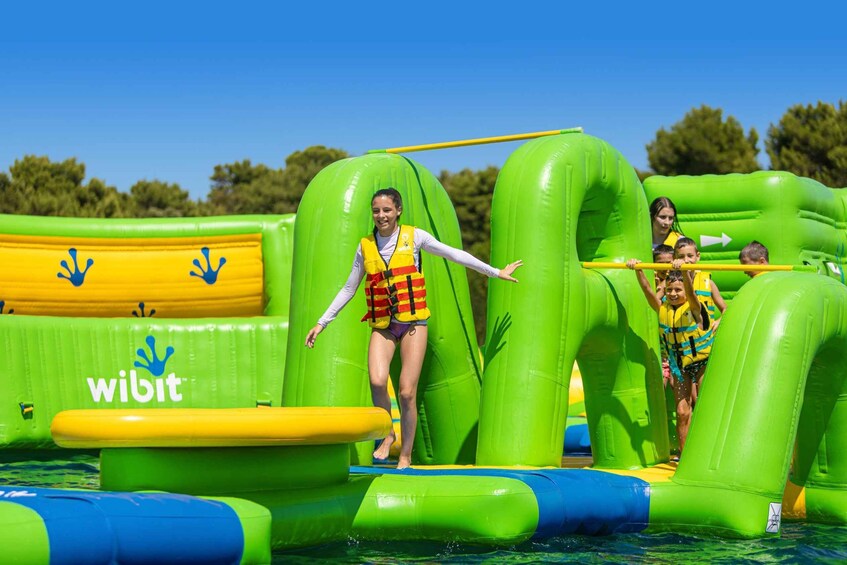 An inflatable water park with green and yellow play structures. 5