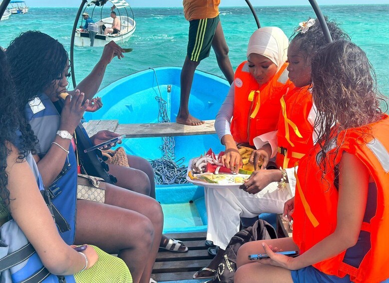 A group of people on a boat with a table of food. 2