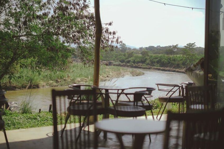Outdoor seating with a view of a river and greenery. 4