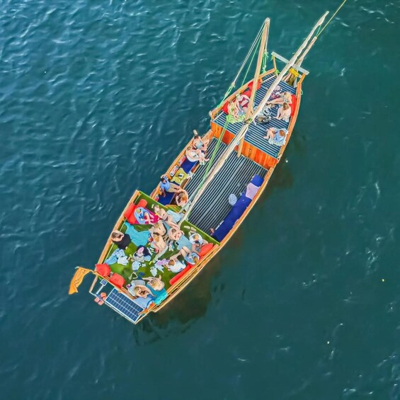 Un bateau coloré, avec des personnes à bord, flottant sur l’eau. 3