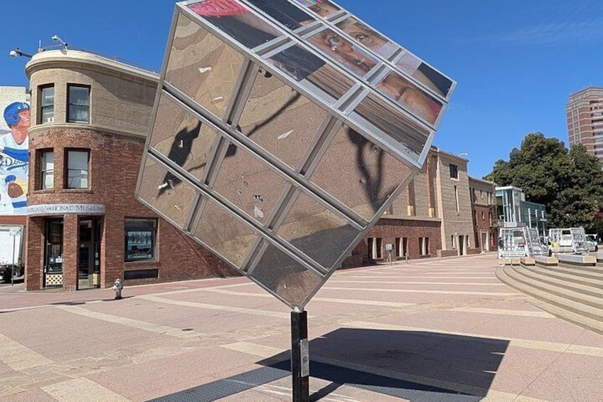 Una escultura de vidrio con un jugador de baloncesto, un museo y un edificio con un mural. 3