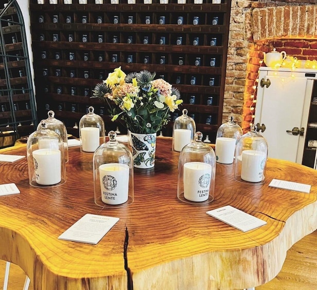 A wooden table with candles and a vase of flowers. 1