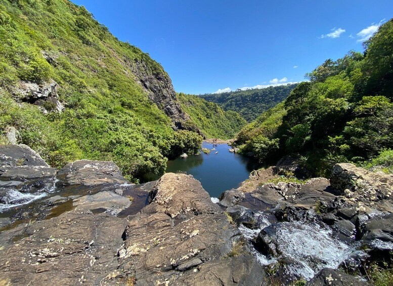 A river flowing through a valley with rocky terrain and dense green foliage. 5