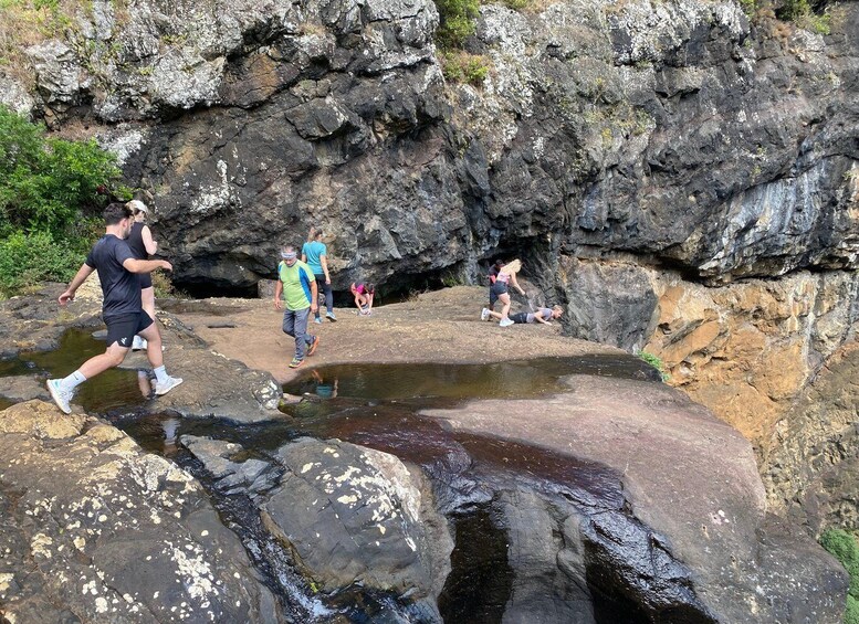 People walking on rocky terrain with a water body. 4