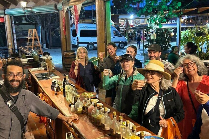 Eine Gruppe von Menschen an einer Bar mit Flaschen und Gläsern auf der Theke. 2