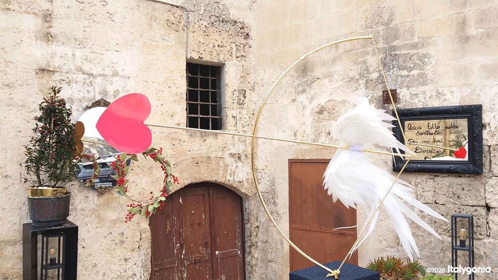 A white dove with a heart-shaped balloon attached to a bow, flying towards a door. 5