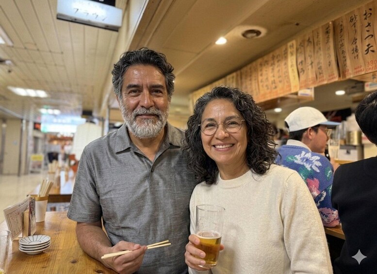 A man and a woman at a restaurant with wooden tables and Japanese writing on the wall. 2