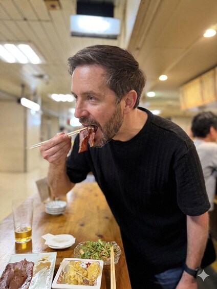 A person eating at a table with various dishes, including meat and vegetables. 5
