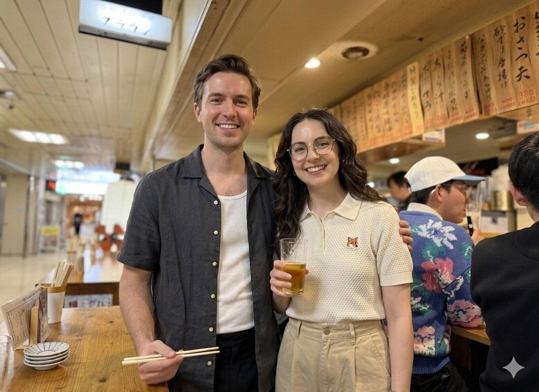 Two people standing at a restaurant table with a menu and chopsticks visible. 3
