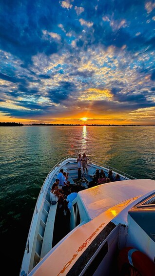 A boat with people on board during sunset. 3