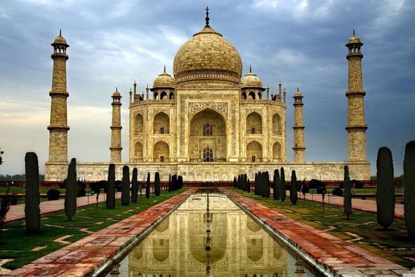 The Taj Mahal with its reflection in the water, four minarets, and a symmetrical garden. 5
