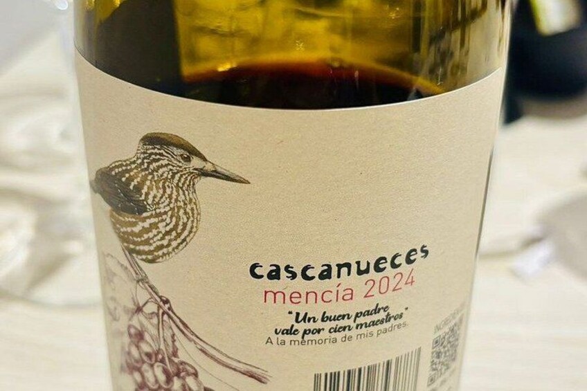 A wine bottle with a label featuring a bird illustration and text. 3