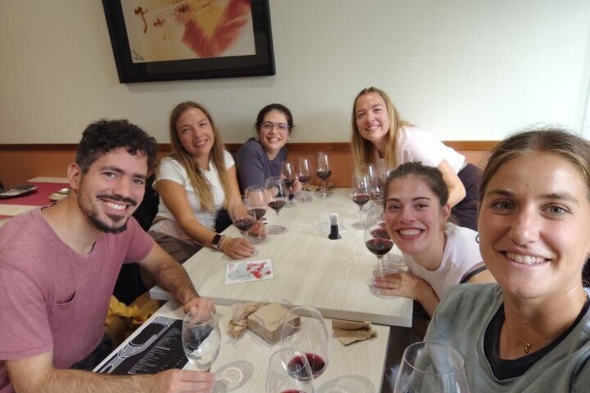A group of people seated at a table with wine glasses and a menu. 3