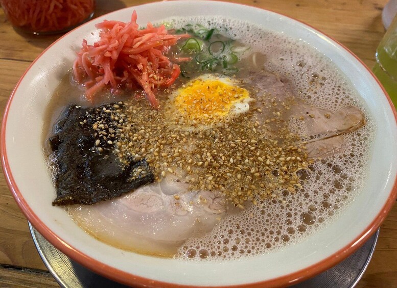 A bowl of ramen with toppings including seaweed, egg, and vegetables. 2