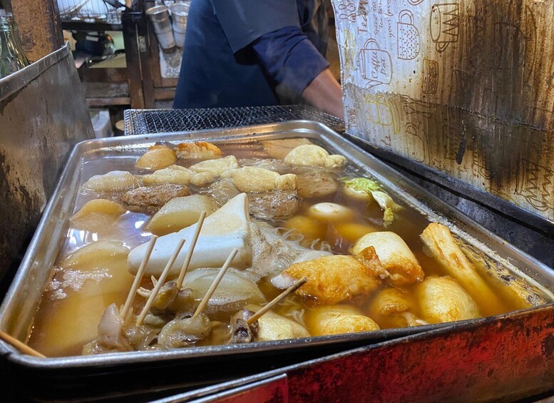 A hot pot with various ingredients simmering in a metal pot. 3