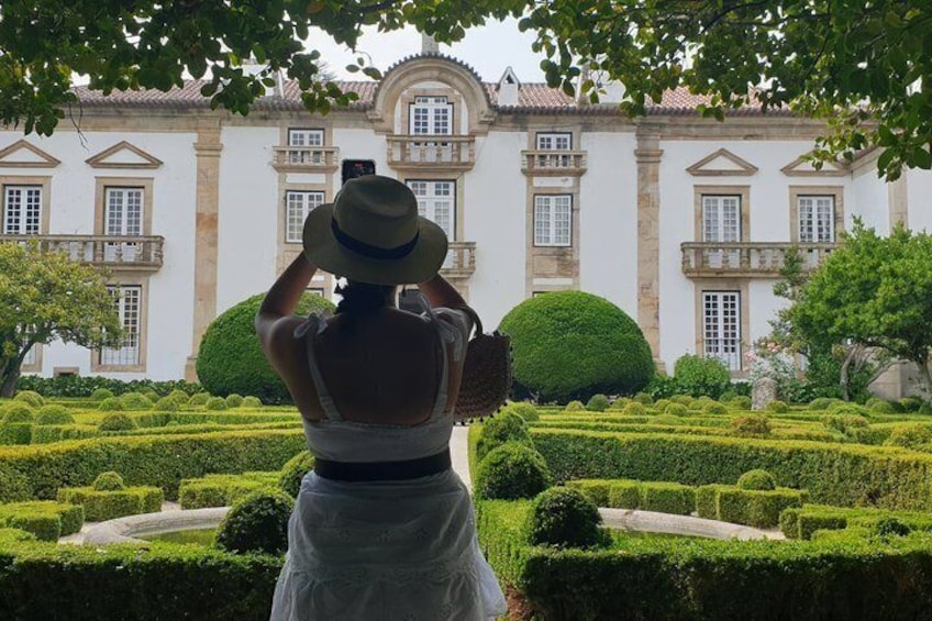 A person taking a photo of a historic building with a garden. 5