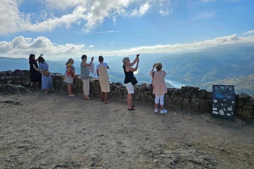 A group of people standing on a rocky outcrop overlooking a valley. 1