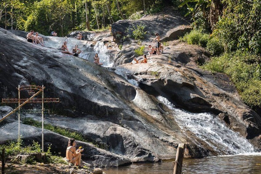 A natural water feature with people relaxing and socializing. 2