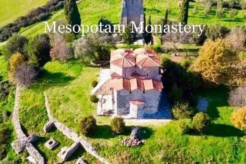 Mesopotam Kloster omgivet af grøn vegetation og stengårdsbygninger. 3