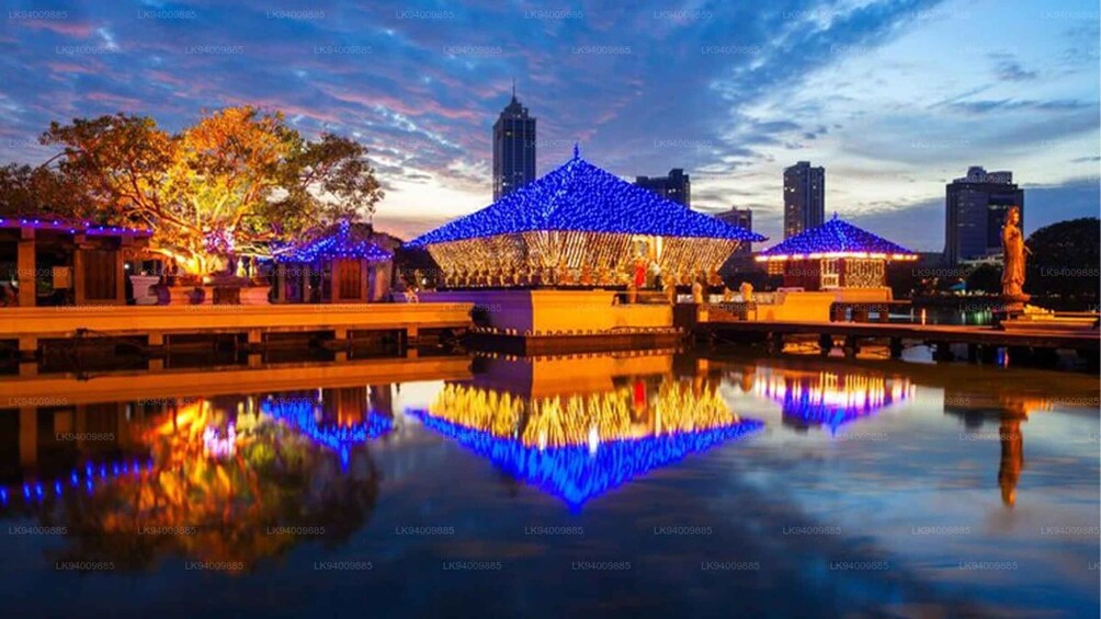 A night scene with illuminated structures and a calm water body reflecting the lights. 5
