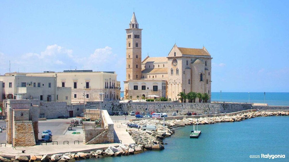 A coastal town with a prominent tower, a large building with a clock, and a marina with boats. 4