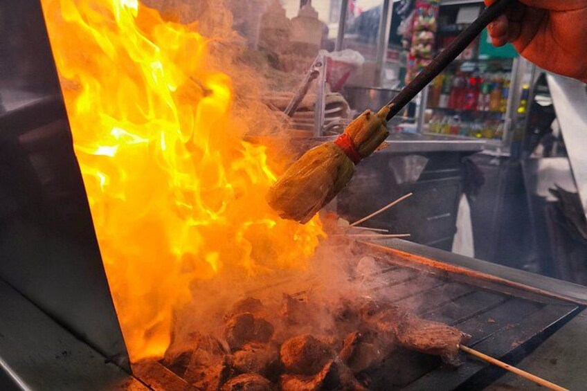 A cooking process with flames and a metal grill. 2