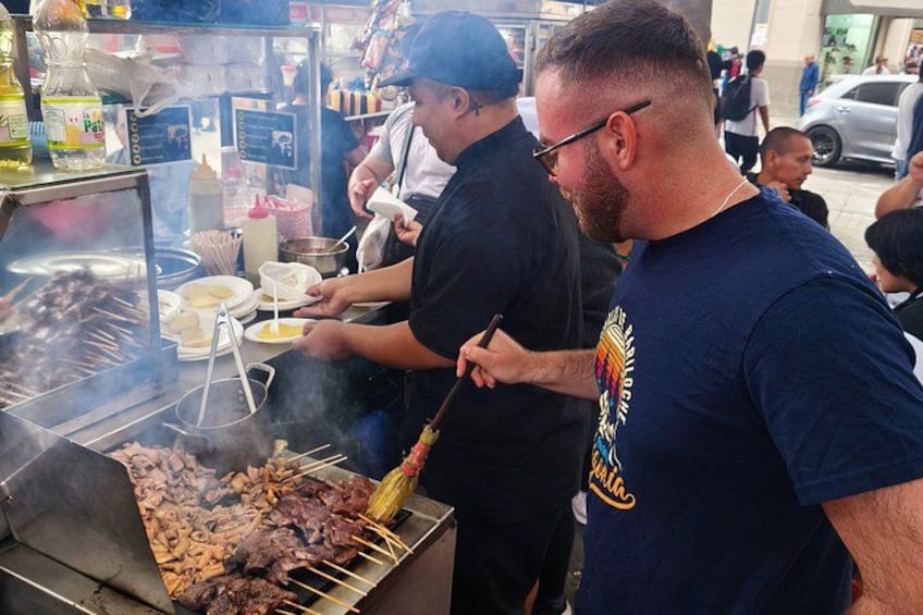 A person grilling meat on a barbecue. 1