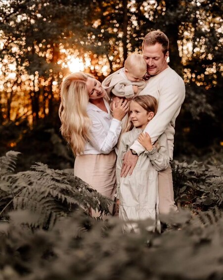 A family in a forest with sunlight filtering through trees. 2