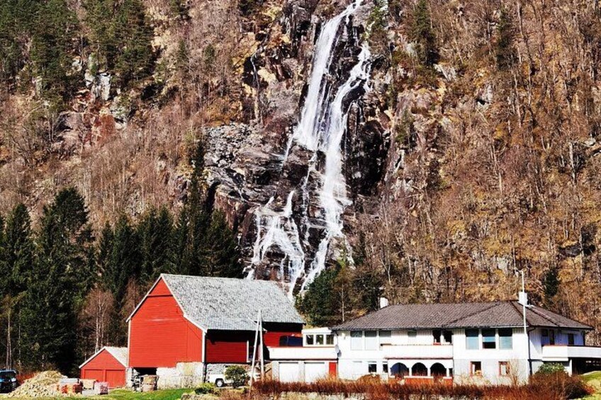 Een waterval, een rode schuur en een wit gebouw met een schuin dak. 5
