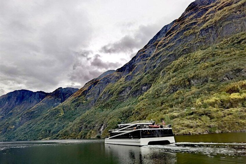 A boat on a calm lake surrounded by mountains. 1