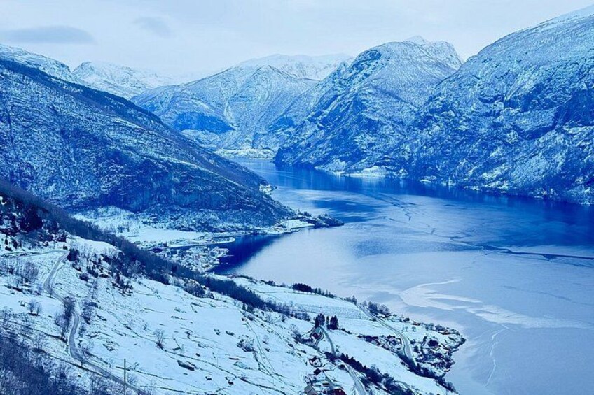A snow-covered mountainous landscape with a lake. 2